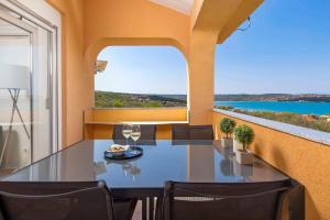 Un comedor con una mesa de cristal y sillas. en Apartment in Klimno - Insel Krk 49859, en Klimno