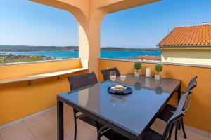 - Balcón con mesa de comedor y vistas al agua en Apartment in Klimno - Insel Krk 49859, en Klimno