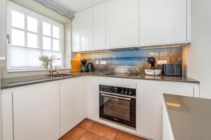 a white kitchen with a sink and a stove at Strandpirat in Wenningstedt