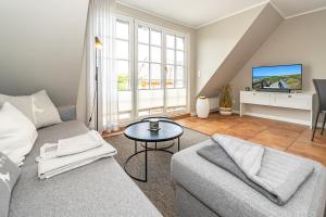 a living room with a couch and a tv at Strandpirat in Wenningstedt