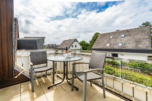 a patio with a table and chairs on a balcony at Strandpirat in Wenningstedt