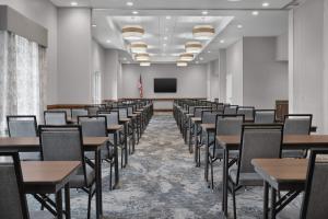 维洛海滩希尔顿维罗海滩市区汉普顿套房酒店 的一间空房间，里面有桌椅和屏风 更多37张照片