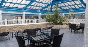 a restaurant with tables and chairs and a blue ceiling at Best Western Weymouth Hotel Rembrandt in Weymouth