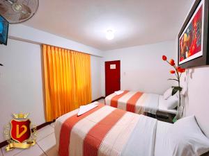 a hotel room with two beds and a window at Veneccia Gold Hotel in Chiclayo