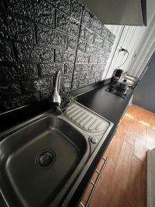a kitchen with a sink and a brick wall at Oasis Mini Deptos in Calama