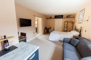 a living room with a couch and a bed at Studio Sleeps 2 w HotTub-Garden-PetsOK-Parking in Cromer