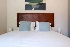 a bedroom with a white bed with blue pillows at GuestReady - Golden hour in Matosinhos in Matosinhos