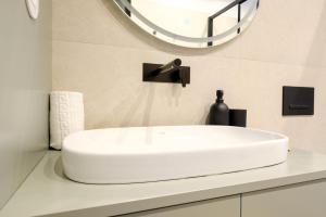 a white sink in a bathroom with a mirror at GuestReady - Golden hour in Matosinhos in Matosinhos