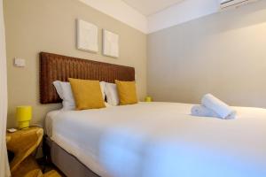 a bedroom with a large white bed with yellow pillows at GuestReady - Golden hour in Matosinhos in Matosinhos