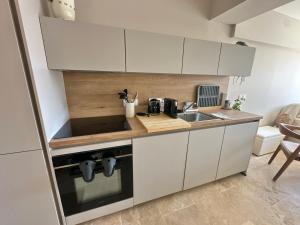 a kitchen with white cabinets and a sink at Appartement à Collioure pour familles avec piscine et parking - FR-1-309-529 in Collioure