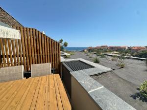 a deck with a wooden table and chairs and the ocean at Appartement à Collioure pour familles avec piscine et parking - FR-1-309-529 in Collioure