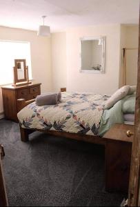 una camera da letto con un letto, un comò e uno specchio di Blyton 2-Bed Cottage Parking 30m to Lincoln a Blyton