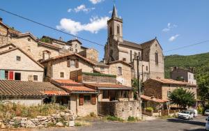 a group of buildings with a church in the background at Cozy Dourbie terrasse fibre tv parking in Millau
