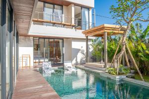 a house with a swimming pool in front of a house at Narawangsa Villa 4br Amazing Sunset Rooftop in Kerobokan