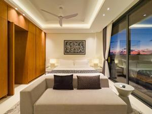 a bedroom with a bed and a large window at Narawangsa Villa 4br Amazing Sunset Rooftop in Kerobokan