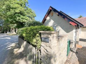 a house with a stone wall next to a fence at The Dairy cottage with garden and parking in Olveston