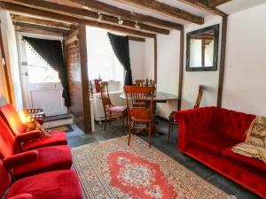 un soggiorno con un divano rosso e un tavolo di The Little Laura Ashley House a Machynlleth
