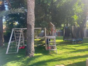 a park with a tree with a ladder and a playground at Open Sky Villa in Denia