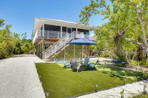 a house with a patio with chairs and an umbrella at Little Gasparilla Island Escape on Private Island! in Placida