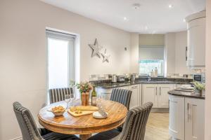 a kitchen and dining room with a wooden table and chairs at No 5 Darcy Mews in Richmond