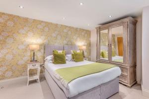 a bedroom with a large bed with green pillows at No 5 Darcy Mews in Richmond
