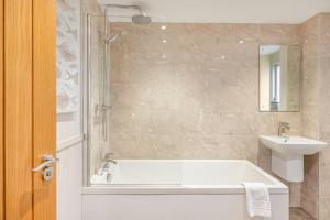a bathroom with a tub and a sink at No 5 Darcy Mews in Richmond