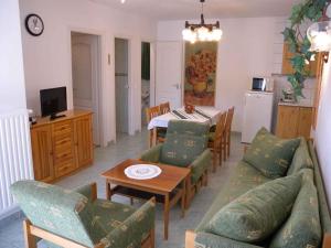 un salon avec un canapé et une table avec des chaises dans l'établissement Apartment Zalakaros 5, à Zalakaros