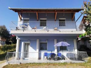 une maison avec un balcon avec des chaises et un parasol dans l'établissement Apartment Zalakaros 5, à Zalakaros