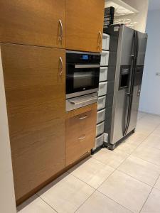 a kitchen with wooden cabinets and a stainless steel refrigerator at Vakantiehuis met 1 slaapkamer in Epe