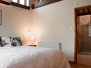 una camera con letto bianco e tavolo con lampada di Byre Cottage - Meadowbrook Farm a Thame Altre 3 foto