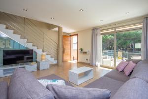 ein Wohnzimmer mit Sofa und Fernseher in der Unterkunft Joan in Can Picafort