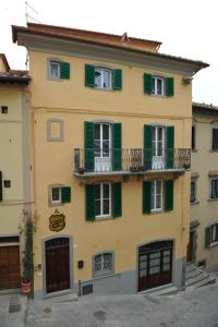 un gran edificio amarillo con ventanas con contraventanas verdes en Bed & Breakfast Viziottavo, en Castiglion Fiorentino