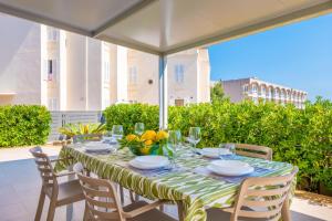 einen Tisch mit einer grünen und weißen Tischdecke auf einer Terrasse in der Unterkunft Antonia in Can Picafort