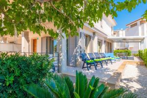 eine Terrasse eines Hauses mit Stühlen und Bäumen in der Unterkunft Antonia in Can Picafort