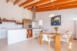 a kitchen with a wooden table and white cabinets at El Paraiso (Porto Cristo) in Porto Cristo