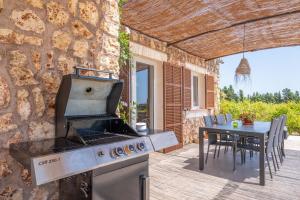 a outdoor kitchen with a grill and a table at El Paraiso (Porto Cristo) in Porto Cristo