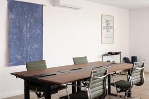 a conference room with a wooden table and chairs at Outsite Private Villa with Infinity Pool and Ocean View in Ericeira