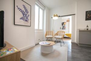 a living room with two chairs and a table at AUDREY-Centre Historique Arènes Antiques-Climatisé in Périgueux