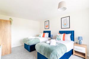 two beds in a bedroom with blue and white at WOW! SeaView Beach Apartment Sleeps 6-Free Parking in Bournemouth
