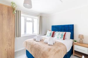 a bedroom with a bed with a blue headboard at WOW! SeaView Beach Apartment Sleeps 6-Free Parking in Bournemouth