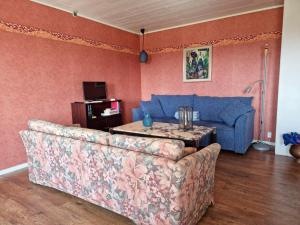 a living room with a blue couch and a table at Spacious holiday home near Halleviksstrand, perfect for families in Ellös