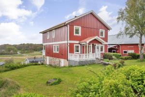 a large red house with a large yard at Spacious holiday home near Halleviksstrand, perfect for families in Ellös
