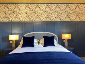 una camera con un letto blu con due lampade di The King's Head a Winchester
