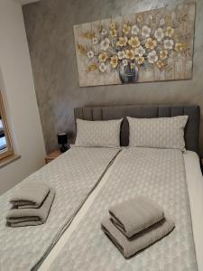 a bedroom with a bed with towels on it at Apartman Amber Vrnjačka Banja in Vrnjci +16 photos