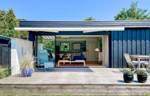 a black shed with a deck and a patio at 2 Bedroom Beautiful Home In Gilleleje in Gilleleje