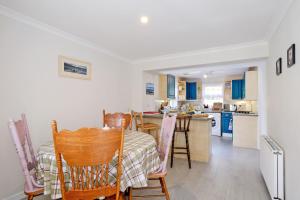 a kitchen and dining room with a table and chairs at Finest Retreats - Corrennie School Cottage in Inverurie