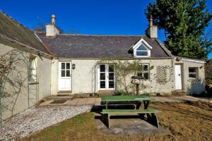 a house with a picnic table in front of it at Finest Retreats - Corrennie School Cottage in Inverurie