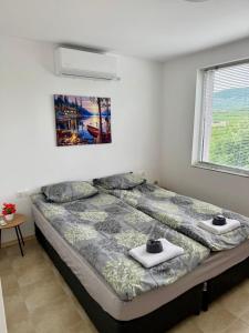 a bedroom with a bed with two towels on it at Къща за гости Галанти Guest house Galanti in Orchenlar