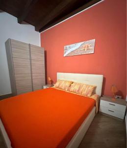 a bedroom with a bed with an orange blanket at Casa Sikelia in Marsala