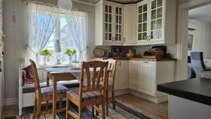 a kitchen with white cabinets and a table and chairs at West Coast house 50m from the harbor in Edshultshall in Hälleviksstrand